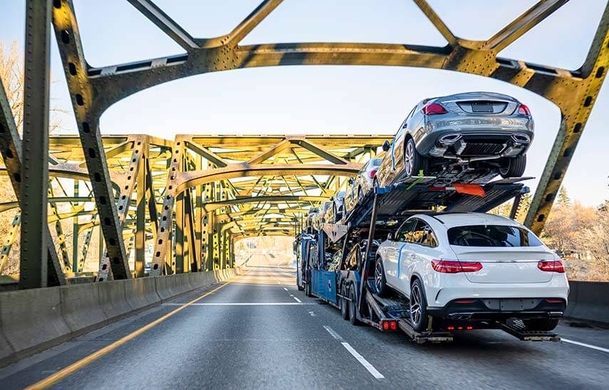 A Two-level Semi-truck Trailer Transports Cars Across a Trussed Bridge | National Transport Services