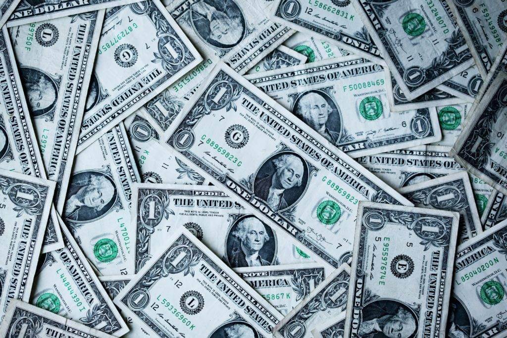 multiple single-dollar bills lay flat. What is the average cost to ship cars?
