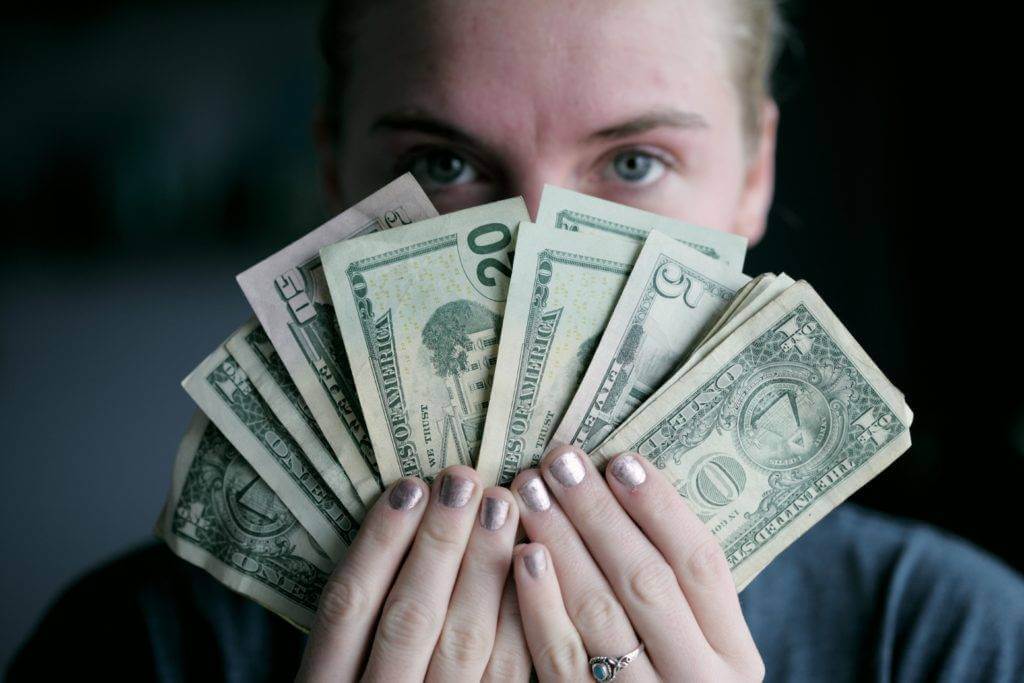 A woman is holding cash in front of the camera. So what should I expect to pay a car shipping company?