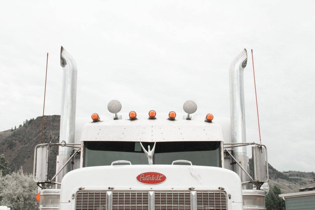 White Peterbilt Semi-Truck facing toward you. Car shipping cost.