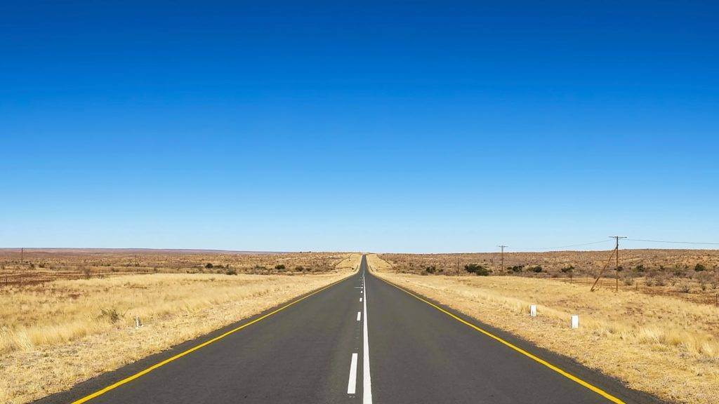 Empty country road that extends for many miles. Car shipping rates.