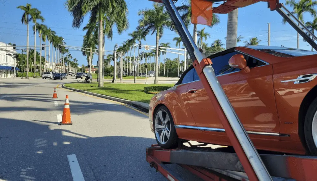 A convertible Bentley Continental GT loaded on a multi-car open trailer.