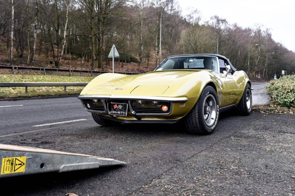 A classic Stingray Chevrolet Corvette is getting loaded onto a car trailer. Looking for "car shipping near me"? Contact us today for a free auto transport quote.