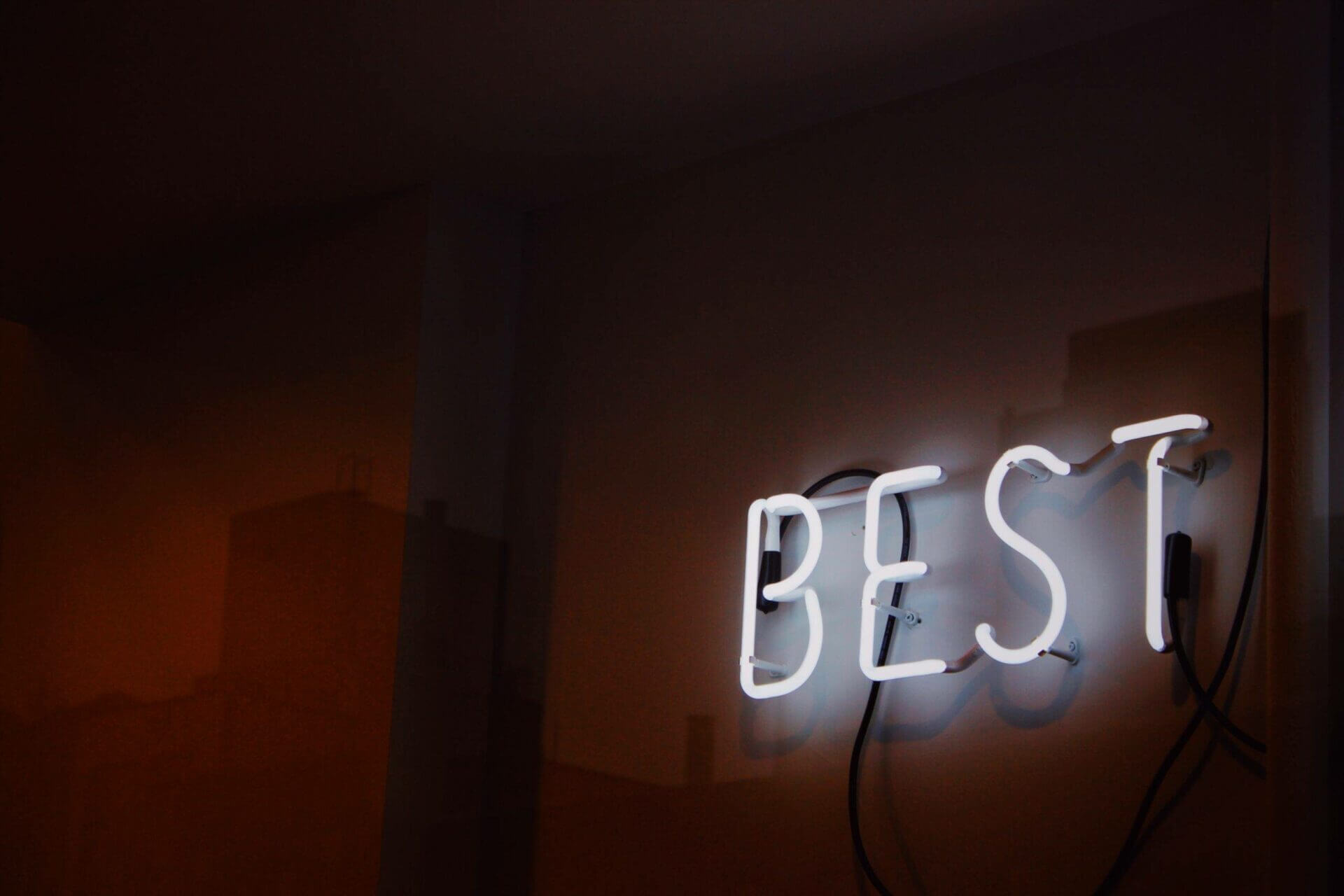 Neon sign that says, BEST. National Transport Services is the best car shipping company.