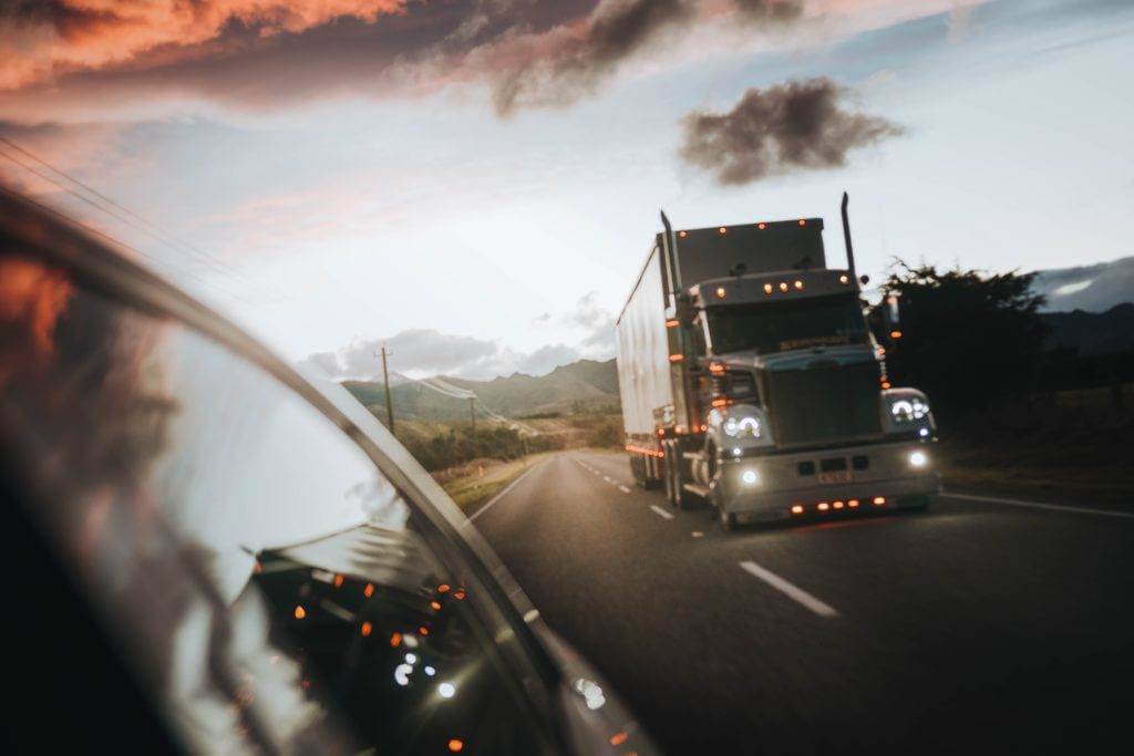 Semi-truck on a dark highway. National Transport Services is the best auto transport company.