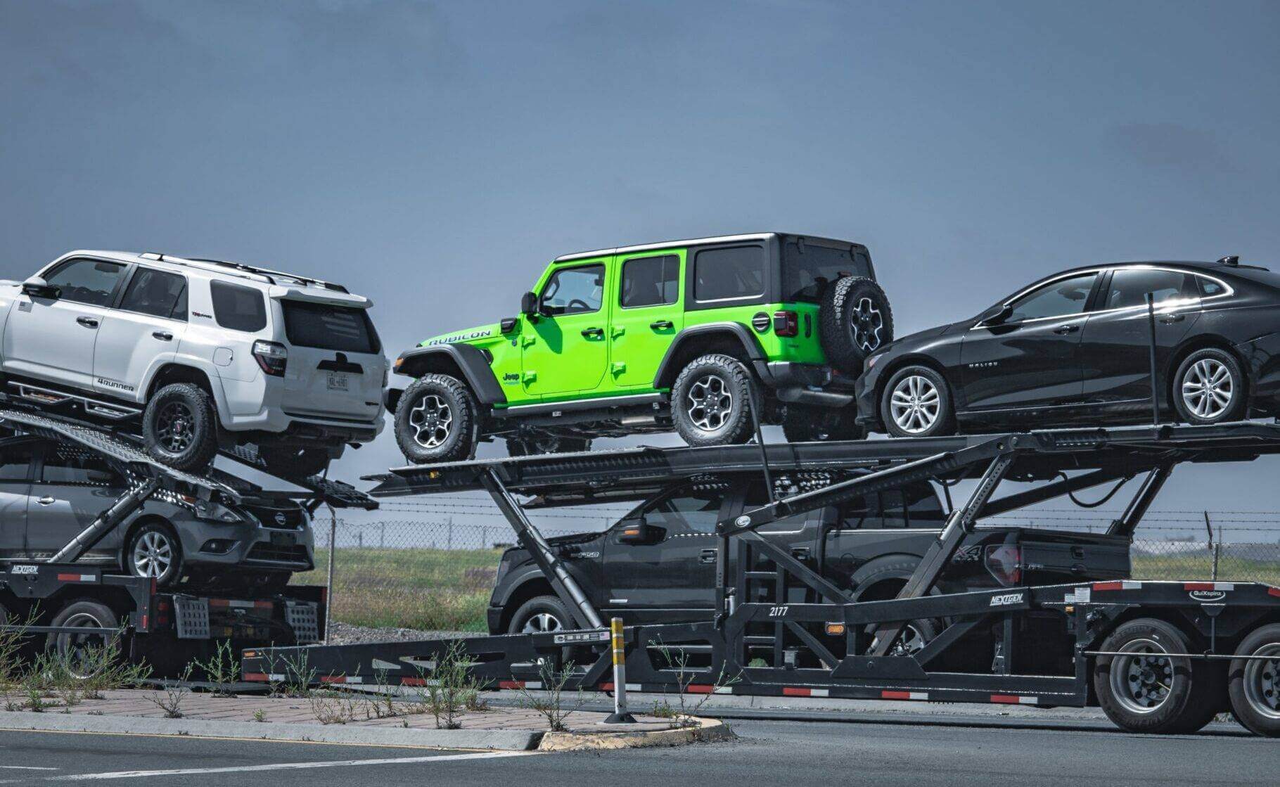 A multi-open car trailer transporting vehicles. What is the shipping cost for cars?