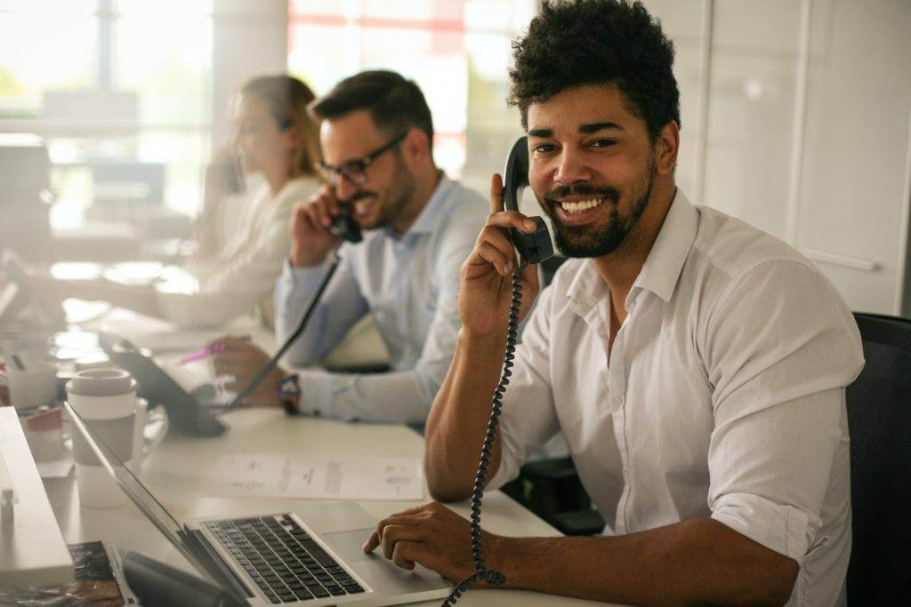 Customer service agent speaking with a client over the phone. Get your credit report and check your credit scores. Then speak with your loan agent about preventing a loan defaults.