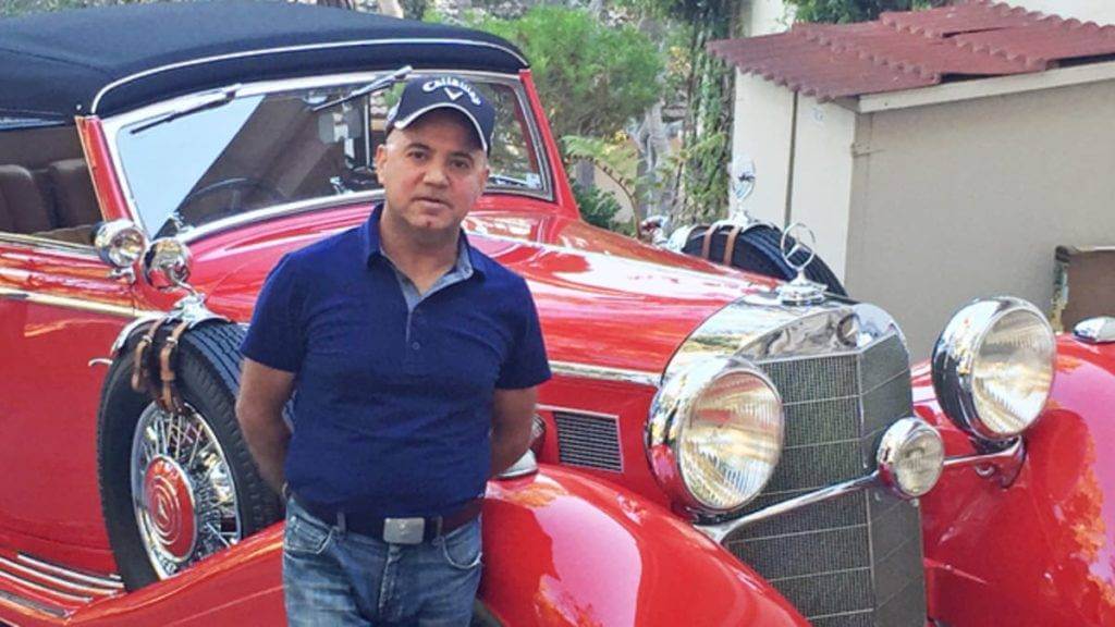 Peter Kumar is standing in front of a 1950s Mercedes Benz Cabriolet. Peter Kumar is the owner of Gullwing Motors New York. They sell classic cars: European Cars, American Cars, and various others.