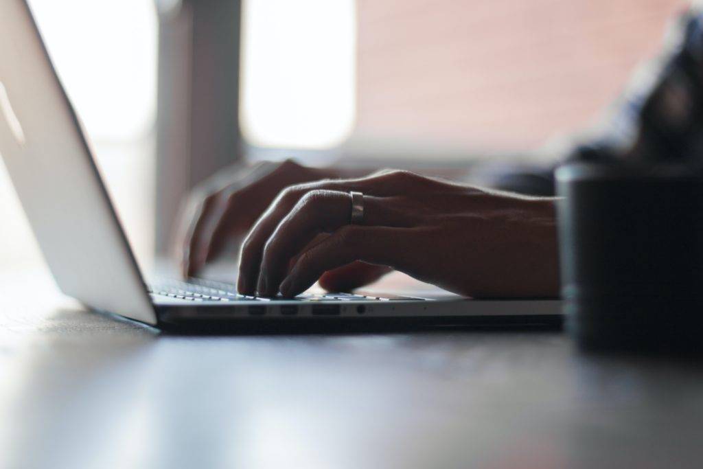 Man typing on his laptop.